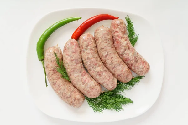 Raw sausages on plate — Stock Photo, Image