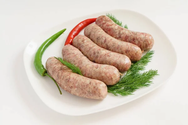 Raw sausages on plate — Stock Photo, Image