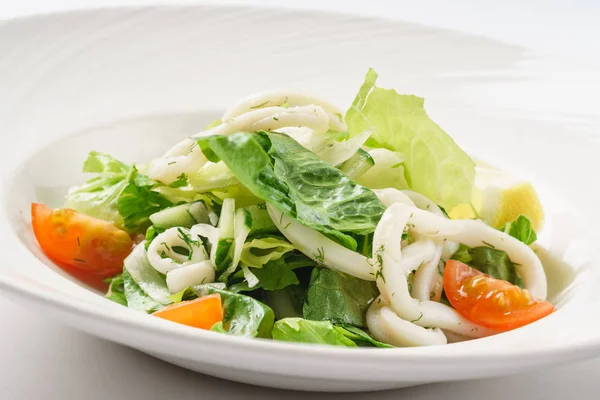 Салат с кальмарами на тарелке — стоковое фото