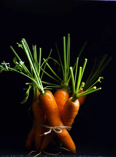 Verse wortelen op zwart — Stockfoto