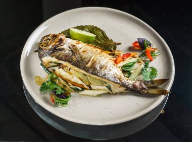 Plaka üzerinde kavrulmuş balık