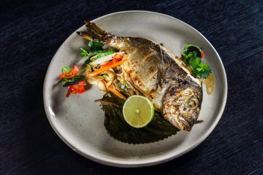 Plaka üzerinde kavrulmuş balık