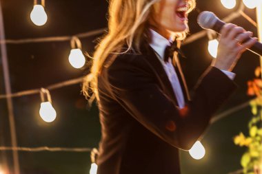 young beautiful woman with microphone singing clipart