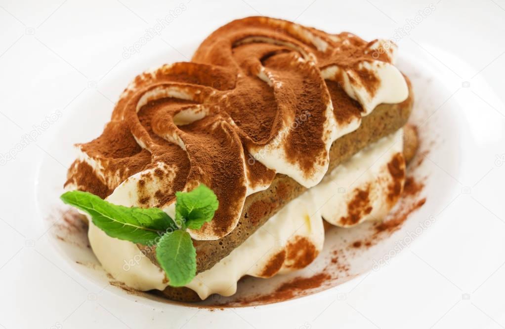 tiramisu cake on white plate, close up