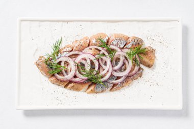 Beyaz tabakta kırmızı soğanlı ringa balığı