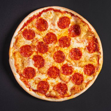 Siyah arka planda lezzetli bir pizza.