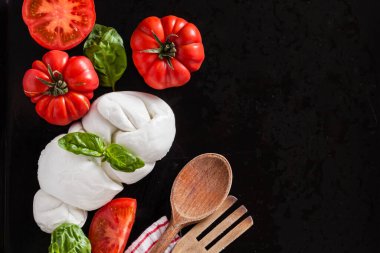 Siyah arka planda mozarella ve olgun domatesler.