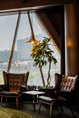 Deri sandalyeler ve klasik lambalar.