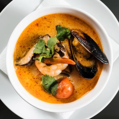 Siyah arka planda deniz ürünleri çorbası.