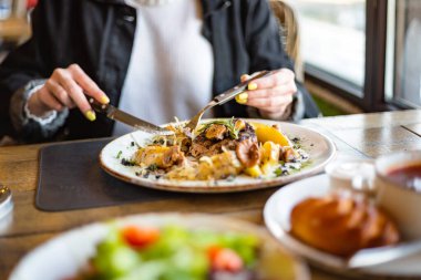 Güzel bir kadın restoranda yemek yiyor.