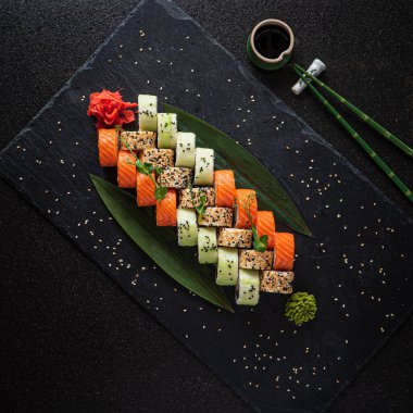 Siyah arkaplanda suşi var.