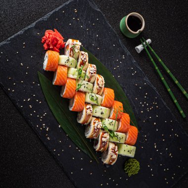 Siyah arkaplanda suşi var.