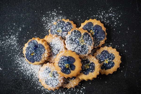 PANSY TOPPED SHORTBREAD COOKIES ON BLACK BACKGROUND