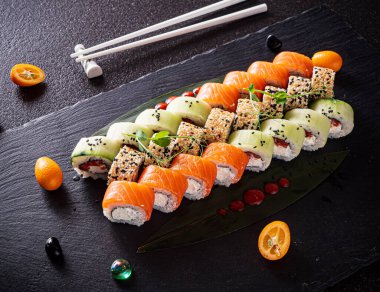 Siyah arkaplanda suşi var.