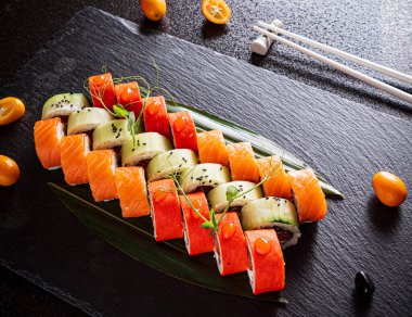 Siyah arkaplanda suşi var.