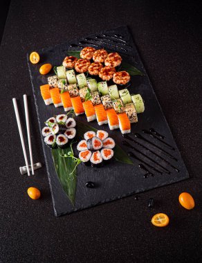 Siyah arkaplanda suşi var.