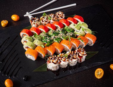 Siyah arkaplanda suşi var.