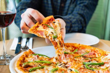 Kafede İtalyan pizzası yiyen bir adam.