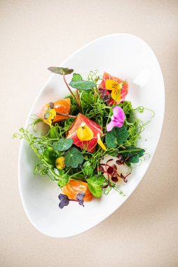 Balık ve yenilebilir çiçekli taze salata.