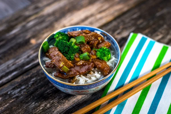 Beef in sauce with broccoli and rice on bowl
