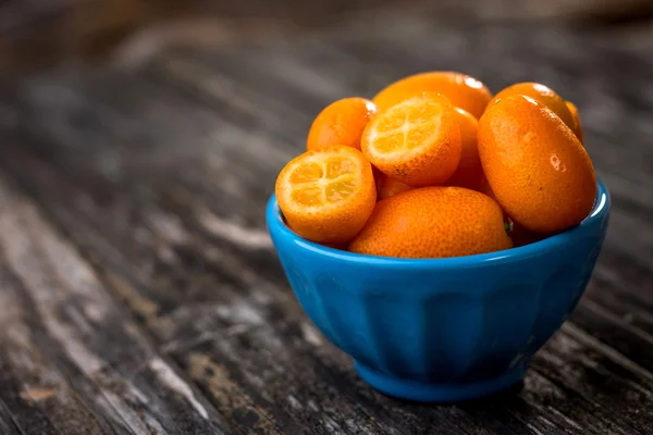 Rohe Orangen Kumquats in blauer Schüssel — Stockfoto