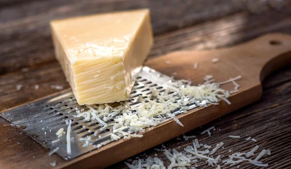Geraspte Parmezaanse kaas op de rasp — Stockfoto