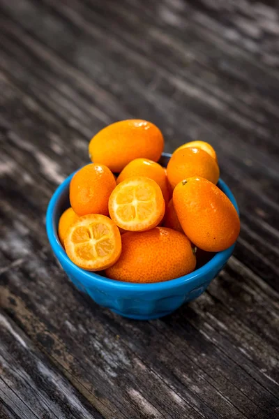 Rohe Orangen Kumquats in blauer Schüssel — Stockfoto