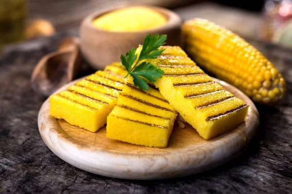 Polenta grelhada na tábua de corte com milho — Fotografia de Stock