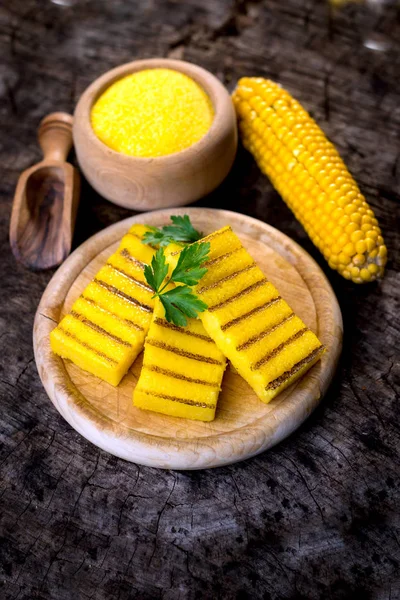 Grilled polenta on cutting board with corn — Stock Photo, Image