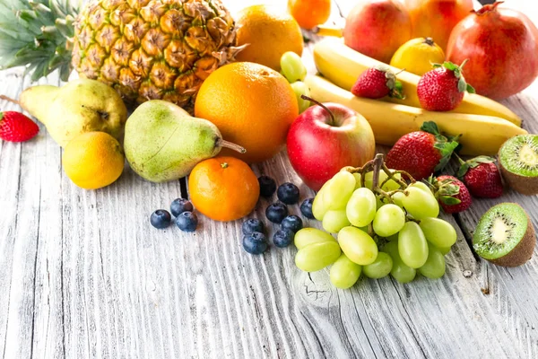 Frutas frescas sobre fondo de madera — Foto de Stock