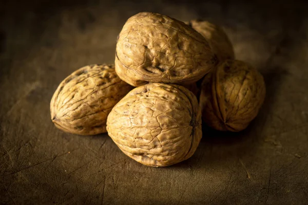 Whole walnuts on wooden table — Stock Photo, Image
