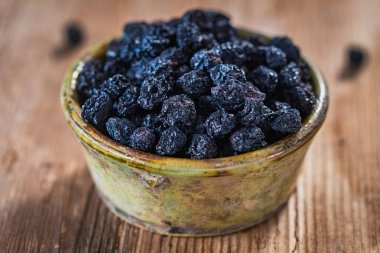 Ahşap arka plan üzerinde seramik plaka Aronia kuru çilek yakın çekim