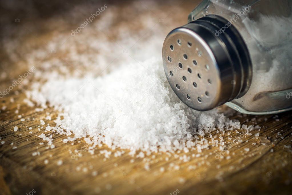 Little heap of salt on wooden background