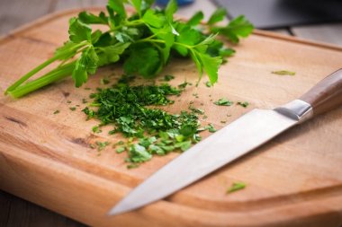 Bıçakla masanın üzerine kıyılmış maydanoz