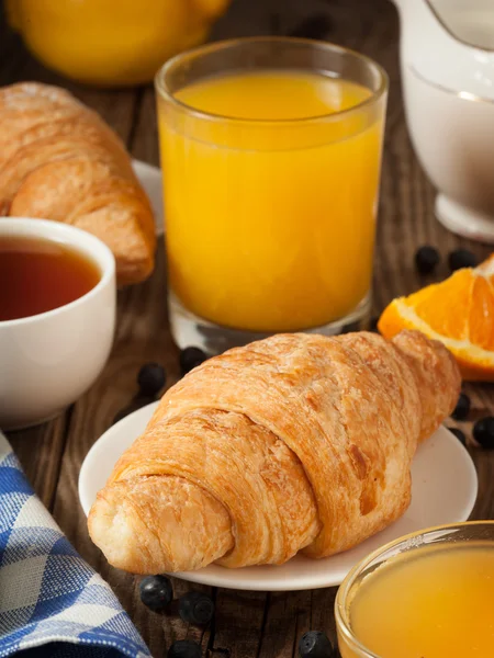 Булочка для завтрака и апельсиновый сок — стоковое фото