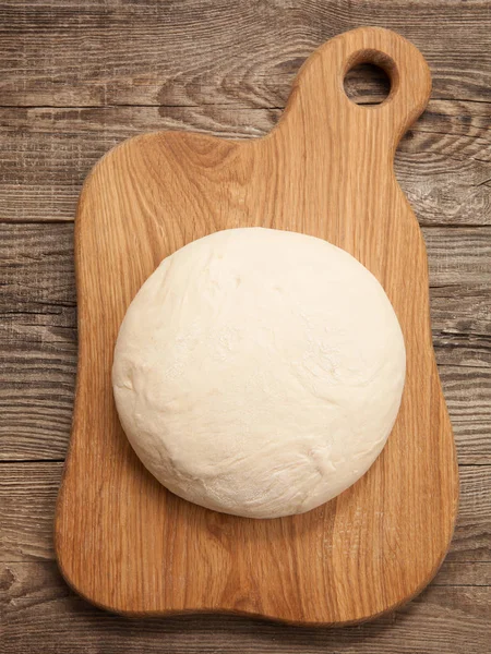 Boule de pâte à pizza sur fond de bois rustique avec époussetage de farine — Photo