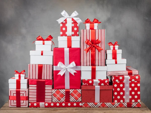Красива гора коробок з подарунками та бантами на сірому фоні — стокове фото
