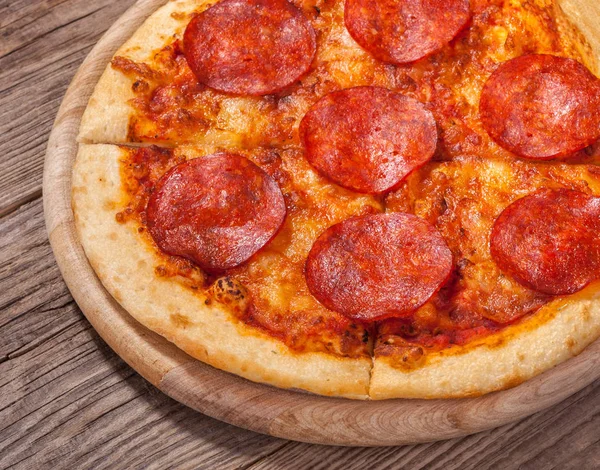 Delicious hot pepperoni pizza on old board — Stock Photo, Image