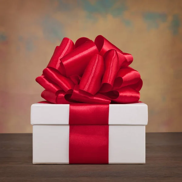 Подарункові коробки з червоною стрічкою та бантом на дошці — стокове фото