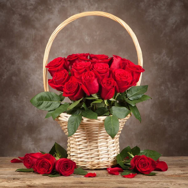 Троянди у вазі на коричневому дерев'яному фоні — стокове фото