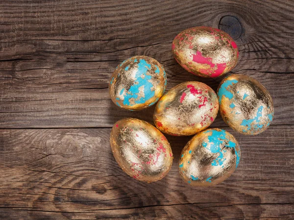 Golden Easter eggs on the old board — Stock Photo, Image