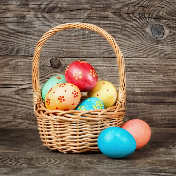 Easter eggs in the basket of wooden table — Stock Photo, Image