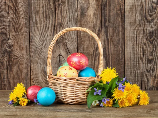 Velikonoční vejce v košíku dřevěný stůl. — Stock fotografie