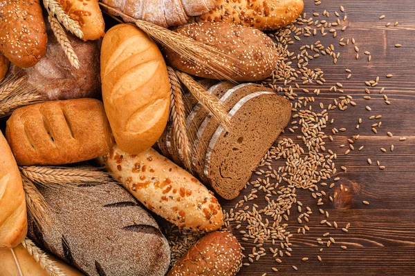 Brotsortiment und Weizenähren auf dem Tisch — Stockfoto