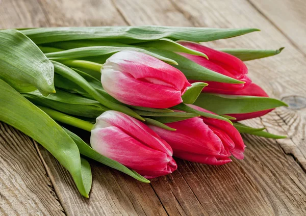Banda jarních tulipánů na staré desce — Stock fotografie