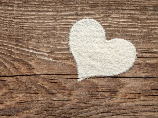 Corazón de harina sobre tabla de madera vieja — Foto de Stock