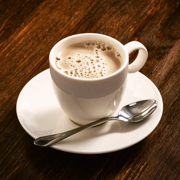 Café en un plato de porcelana blanca en el tablero viejo — Foto de Stock