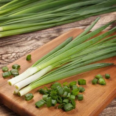 Kesme tahtasındaki taze taze soğanlar..