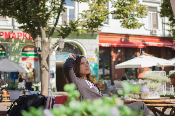 bulanık bir arka plan ile bir şehir sokak kafede güzel kahverengi saçlı kız