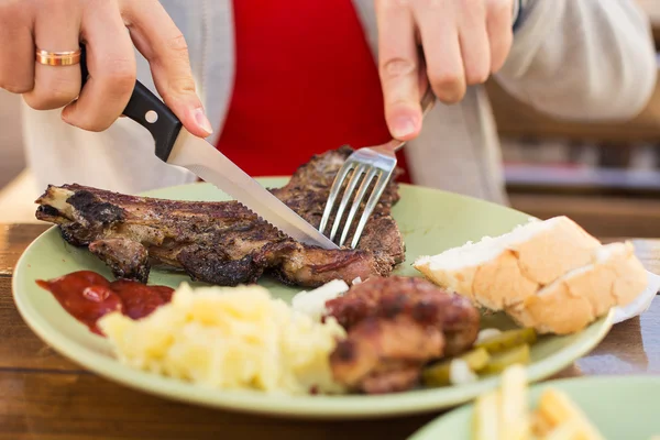 Öğle yemeğinde kafe, patates püresi, adamın elleri ile sığır eti biftek 